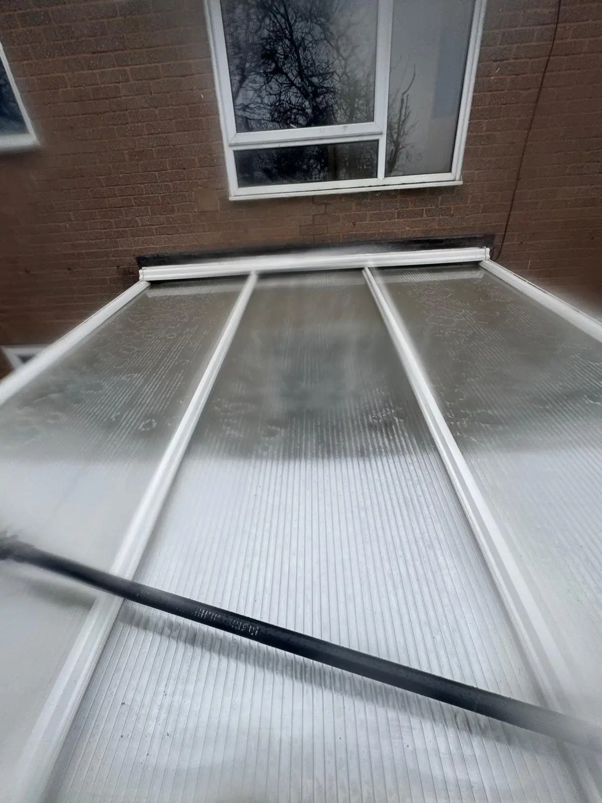 Conservatory roof being pressure washed and cleaned professionally