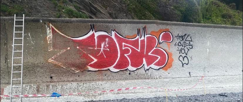 Graffiti on brick wall before professional removal