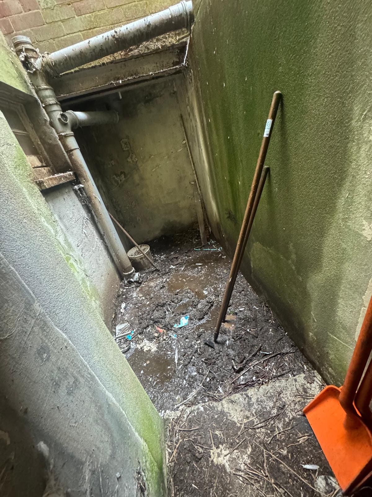 Gutter packed with compacted debris before professional cleaning