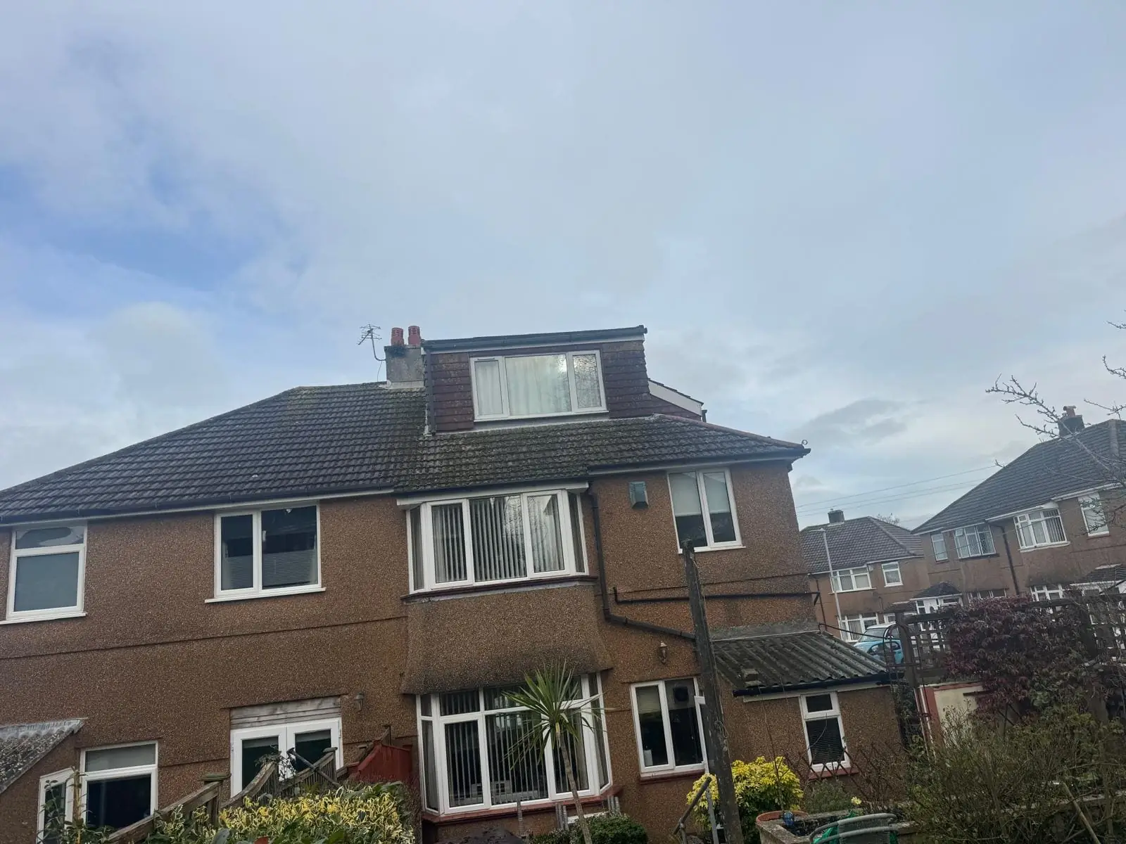 Mossy concrete tile roof requiring professional cleaning